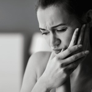 Handling a dental emergency 3 Woman holding her jowl, dealing with a dental emergency
