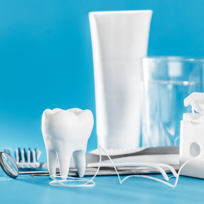 Top tips for maintaining excellent oral hygiene 3 Assortment of dental items, plastic tooth, dental tools, etc. Displayed on a blue background, representing oral hygiene