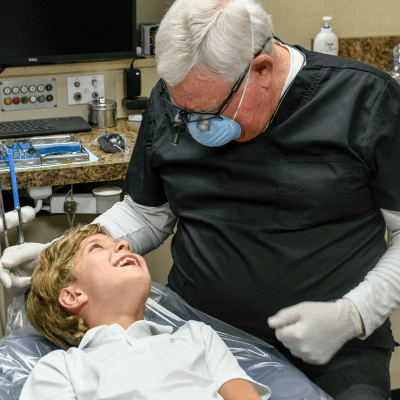 Our story: stewart dental group – a legacy of care in charlotte 3 Dr. Stewart working on a patient's teeth, representing stewart dental group